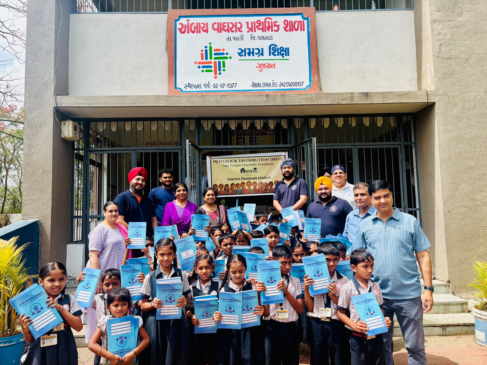 VPCF trustees and volunteers distributing notebooks to students at Ambay Vaghsar Prathmik Shala, Pardi