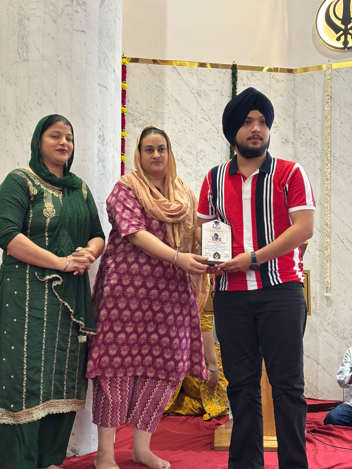 VPCF trustees felicitating a student with a Student Achievement Award plaque