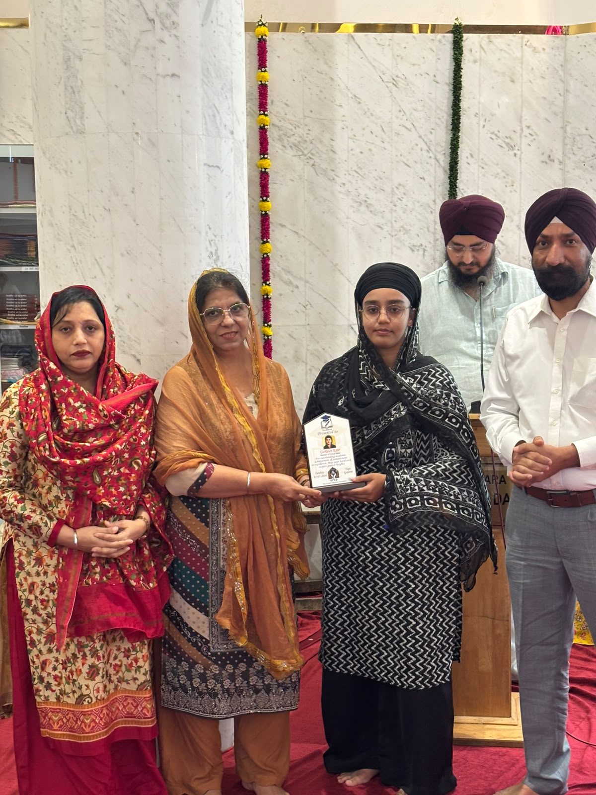 VPCF trustees felicitating a student with a Student Achievement Award plaque